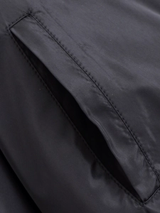 Detail der seitlichen Eingrifftasche an der schwarzen Steppjacke mit präzisen Steppnähten