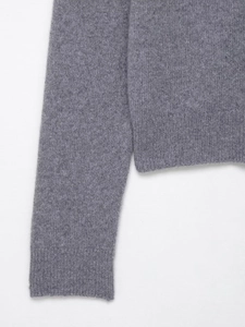 Detailed close-up of ribbed cuffs and hem on a gray knit cardigan sweater for women