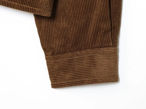Detailed macro view of the brown corduroy jacket sleeve showing stitching and ribbed texture