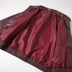 Macro detail of wine red leather jacket showing smooth lining and elasticated hem band