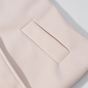 Detail view of light pink wool blend fabric texture and a rectangle pocket flap