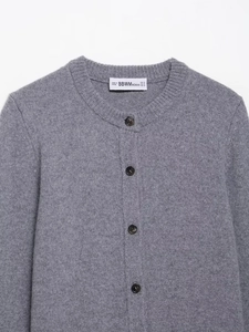 Detail shot of grey knitted cardigan collar with dark buttons and brand size label