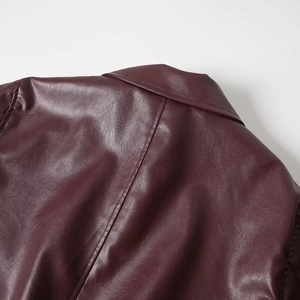 Close-up of premium burgundy faux leather jacket shoulder seams and collar texture