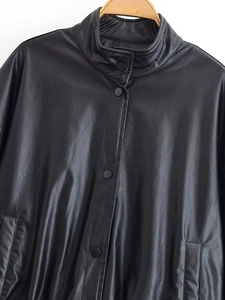 Detail view of black faux leather jacket with stand collar and matte press studs
