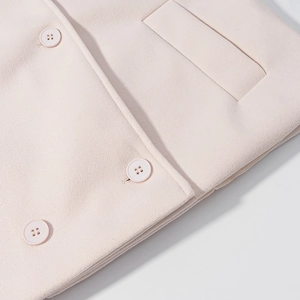 Close-up of pale pink wool coat with double-breasted buttons and fine stitching details