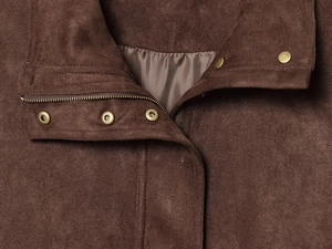 Detail view of smooth metal zipper and snaps on dark brown suede baseball jacket