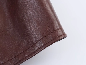 Macro detail of brown faux leather jacket with reinforced double-stitch sewing