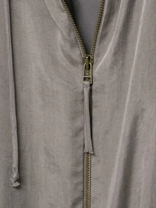 Detail of metal zipper closure and textured twill fabric on grey bomber jacket