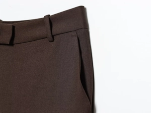 Close-up of high-quality dark brown suit trousers with waist belt loops and side pockets