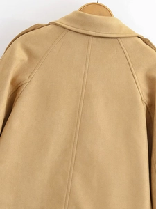 Detail of the back tailoring on a khaki double-breasted trench coat with shoulder epaulettes