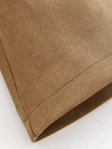 Detailed close-up of brown suede fabric texture and professional stitching on trench coat