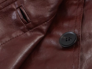 Close-up of brown PU leather texture with dark stitching and black button detail