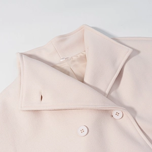 Detail shot of pink wool coat showing collar stitching and color-matched buttons