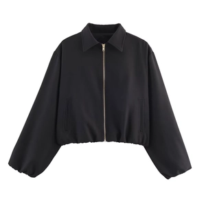 Detail of a black short puff jacket featuring a gold zipper and elastic cuffs