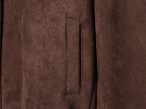 Close-up detail of the welt pocket and soft suede texture on a dark brown jacket