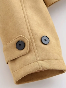 Detailed close-up of khaki faux suede trench coat cuff with black buttons and fine stitching
