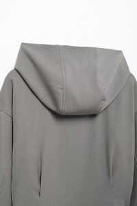 Détail du dos de la veste grise à capuche montrant le tissu sergé et les coutures soignées