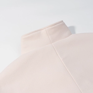 Close-up detail of high collar and stitching on a solid color wool coat for women