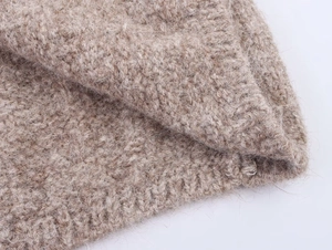 Close-up of oatmeal wool knit fabric showing chunky texture and ribbed detailing