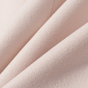 Close-up of premium soft wool blend fabric in pale pink with fine brushed texture