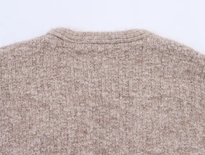 Macro detail of ribbed neckline and brown waffle knit texture on this warm cardigan