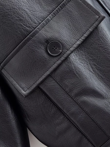Detail of black PU leather jacket with a buttoned flap pocket and precise stitching
