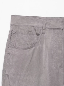 Macro detail of light grey twill fabric trousers showing waist belt loops and pockets