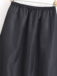 Detailansicht des schwarzen Satin-A-Linien-Rocks mit elastischem Bund und glänzendem Stoffgewebe