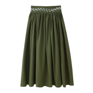 Detail of army green pleated maxi skirt featuring silver sequin leaf embroidery on waist