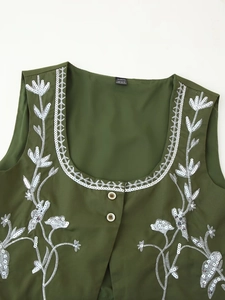 Close-up of sequin embroidery on dark green vest with Aveloria label detail