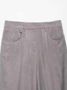 Detailed close-up of grey bomber suit trousers featuring premium suede texture and stitching