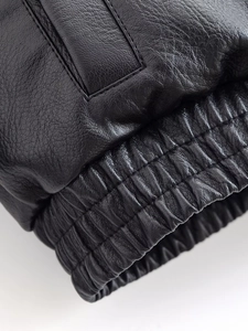 Close-up of premium black PU leather texture with ribbed elastic cuff and neat stitching