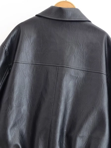 Detailed back view of black PU leather jacket with premium stitching on a wooden hanger