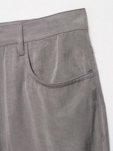 Detailed macro view of gray trousers featuring neat stitching and side pocket design