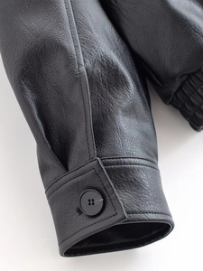 Close-up of black PU leather jacket cuff featuring stitching and resin button detail