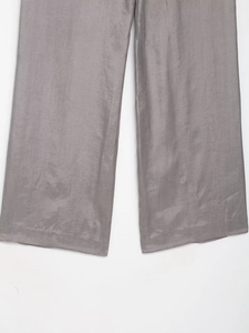 Detail view of grey wide-leg trousers showing smooth lustrous fabric and elegant drape
