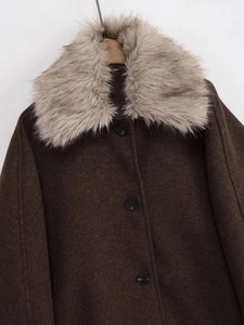 Detail of the oversized faux fur collar and single-breasted buttons on a wool blend coat