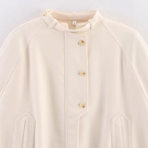 Minimalist cream white stand collar cape coat with amber buttons and raglan sleeves