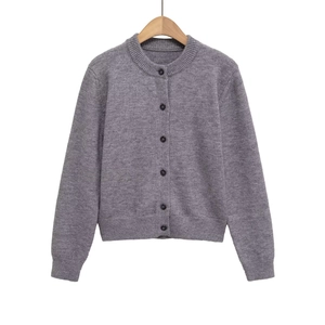 Close-up of gray knit cardigan with round neck, black buttons, and ribbed texture detail