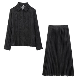 Détail d'un ensemble jupe plissée noire et chemisier transparent montrant la texture