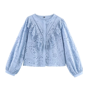 Light blue cotton blouse with embroidery anglaise, V-ruffles and puff sleeves on white background