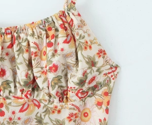 Close-up of floral print mini dress featuring pleated bust detail and thin straps
