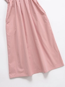 Detailed macro view of pink pleated summer dress showing hidden side pockets and fabric texture
