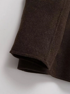 Detailed close-up of dark brown wool coat fabric texture and high-quality sewing craftsmanship