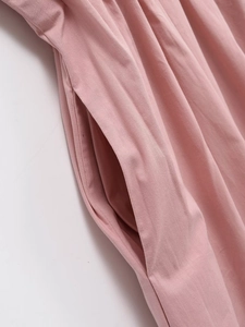 Detail of a pink A-line dress featuring a functional side pocket and cotton fabric texture