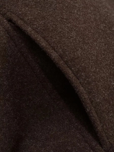 Macro view of dark brown wool fabric texture with fine stitching on minimalist autumn coat