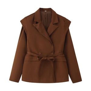 Detail of a dark brown belted blazer with peak lapels and side flap pockets
