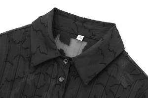 Détail macro du col d'une chemise noire transparente avec texture 3D et taille XS