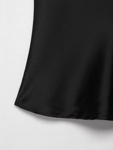 Close-up of black satin fabric showing fine stitching and smooth silk-like texture