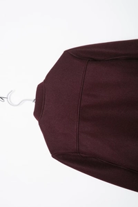 Detail of burgundy wool bomber jacket showing ribbed collar and premium fabric texture
